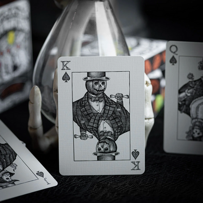 Playing card with a skeleton in a top hat and suit, surrounded by other playing cards.