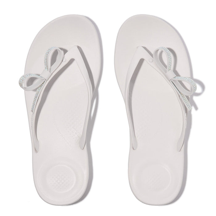 iQUSHION Glitz-Bow flip-flops with cushioned footbed, anatomically shaped straps, delicate bow detail, waterproof and lightweight.