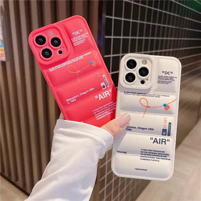 A hand holding a red iphone case with a white phone cover